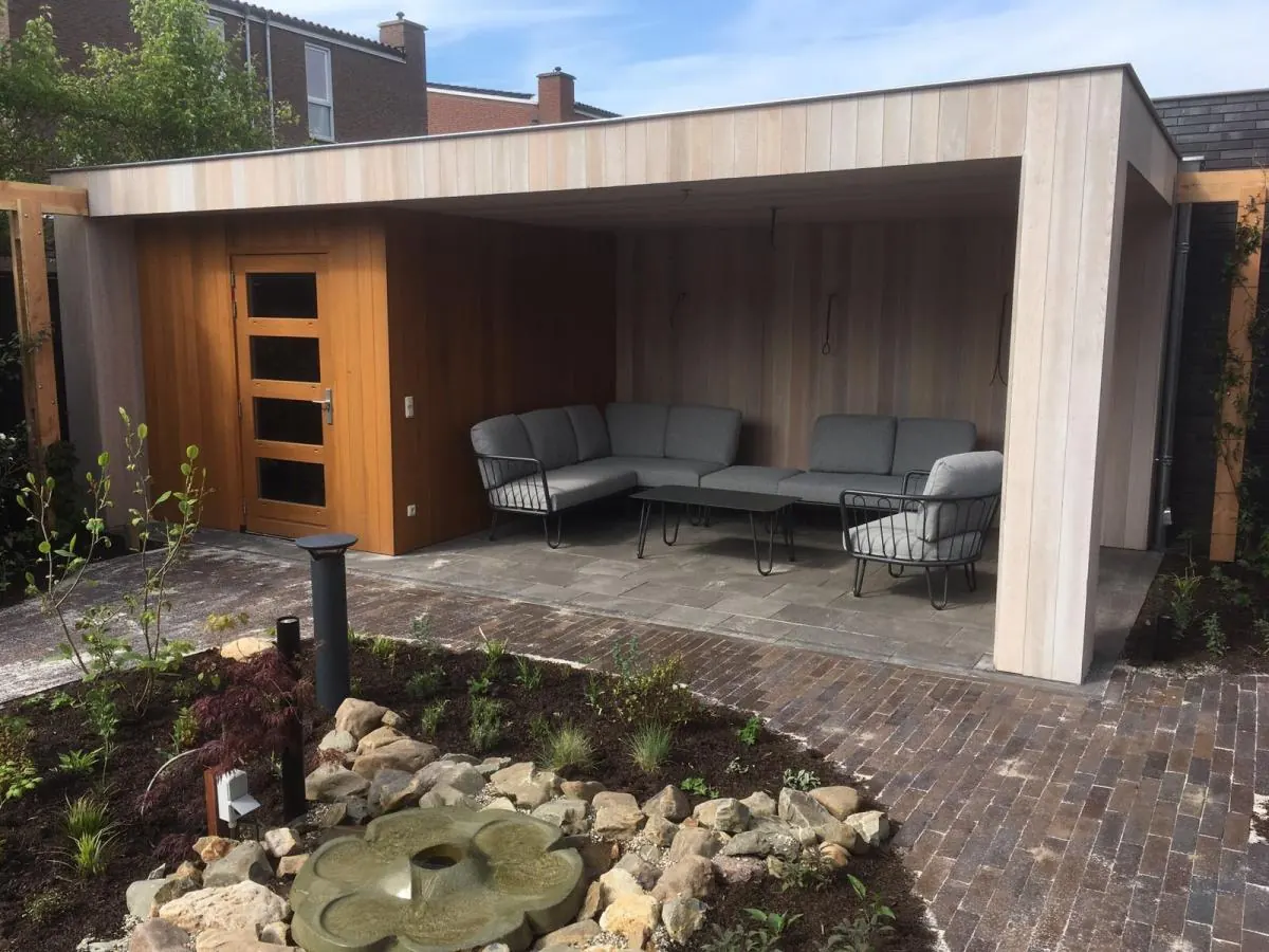 Houten overkapping in een tuin met grind