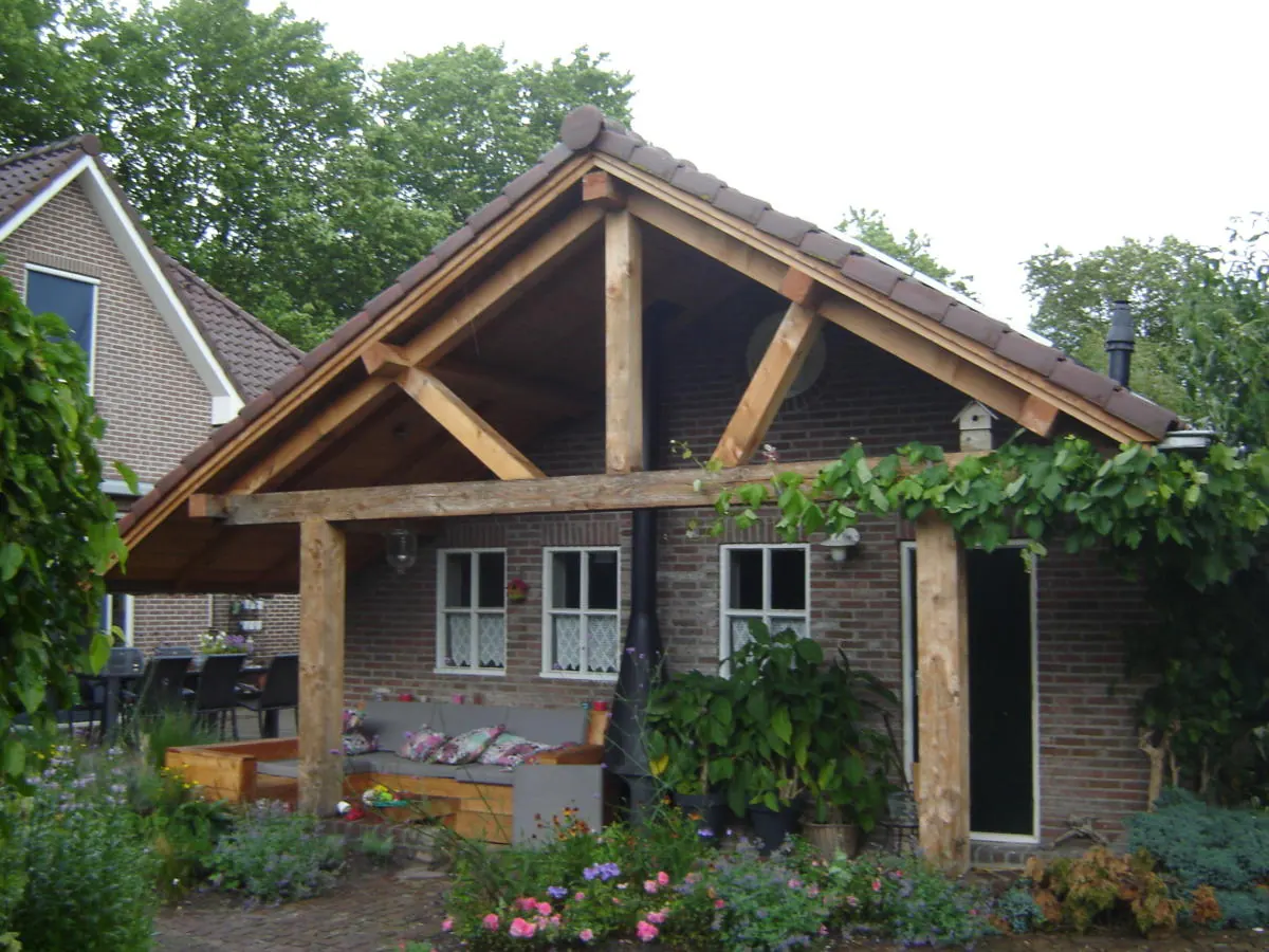 Houten overkapping met puntdak aan een woning