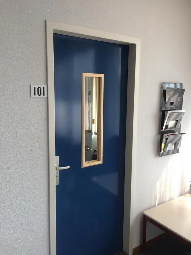 Nieuwe blauwe voordeur met glas in een houten kozijn